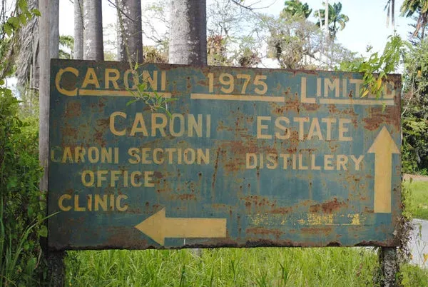 A rusted road sign marking the abandoned Caroni distillery